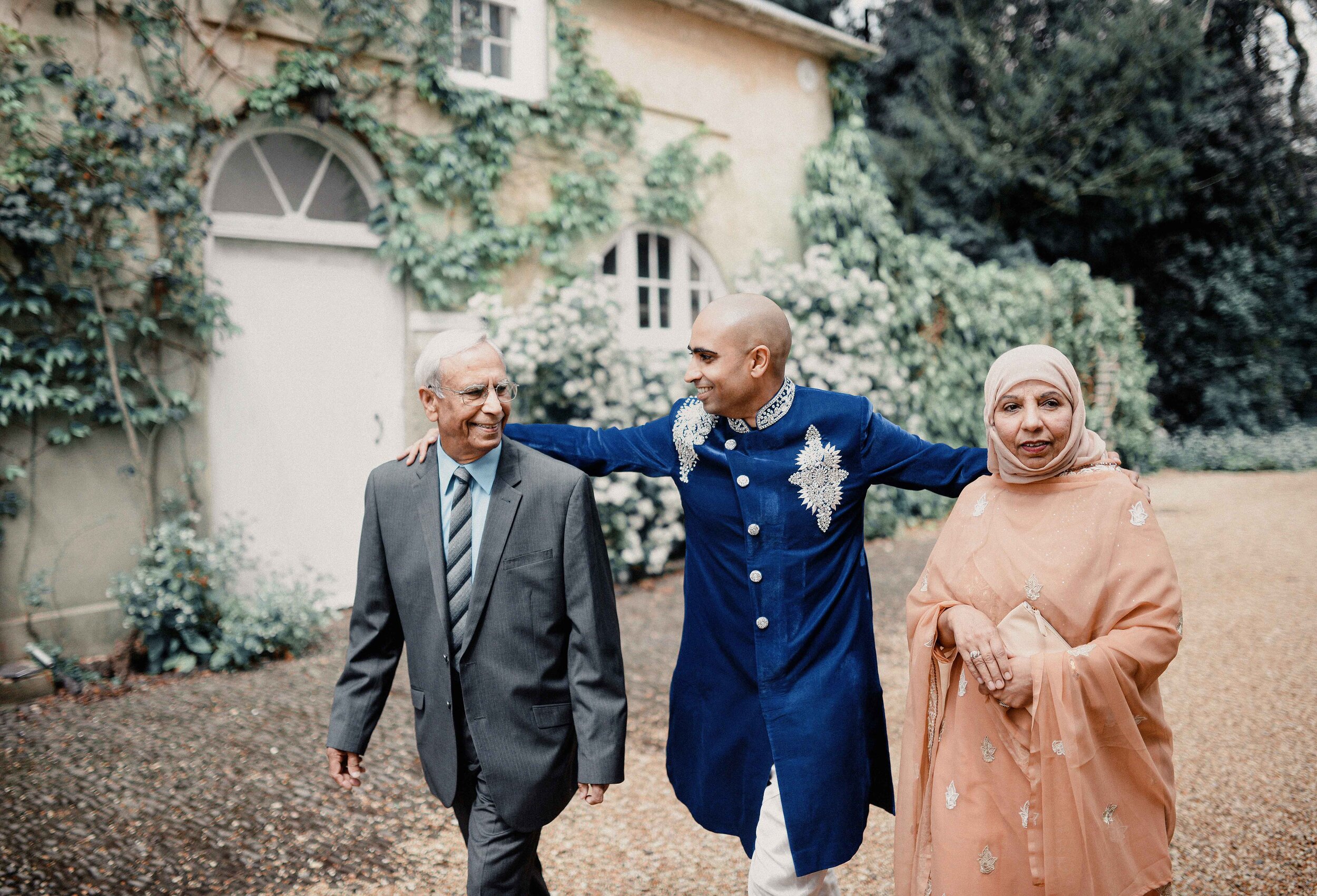 Mixed-religious Yorkshire wedding ceremony. Groom pictured wearing traditional Pakistani attire alongside his parents.